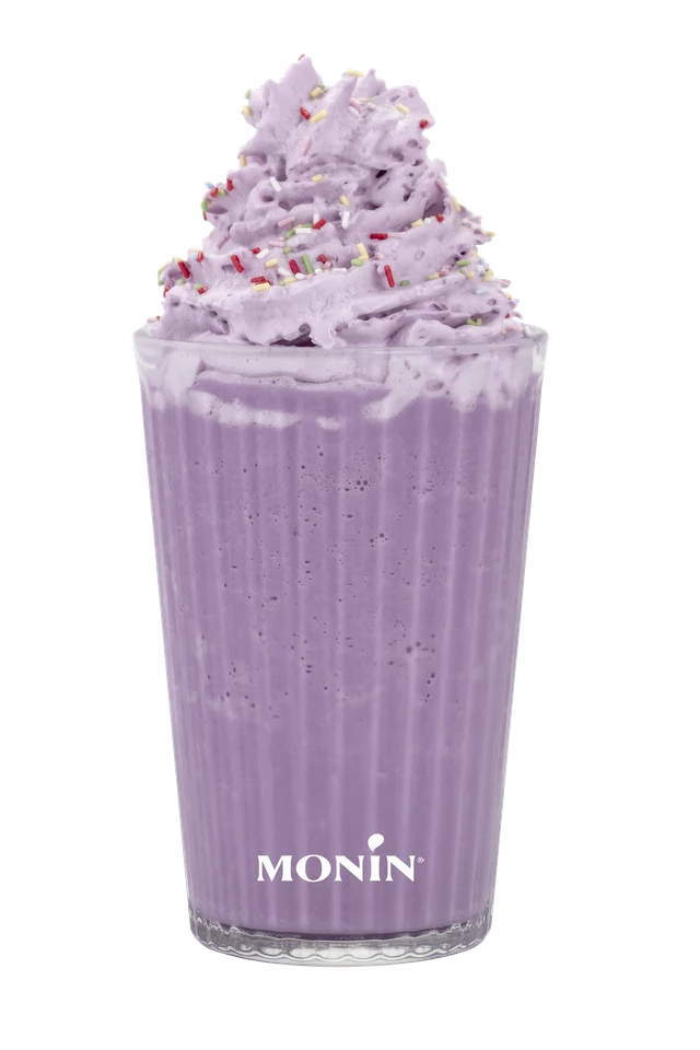 Fialové Ube frappé se šlehačkou a barevným zdobením na průhledném pozadí.